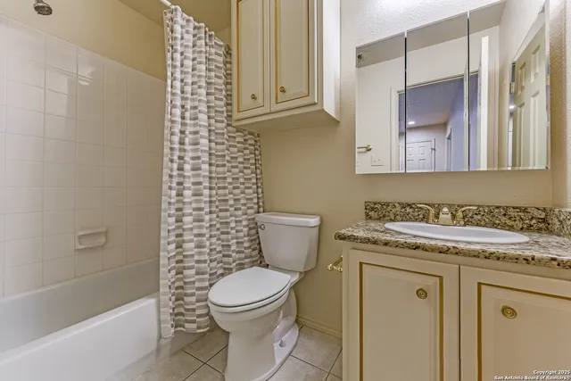 a bathroom with a granite countertop toilet sink and mirror