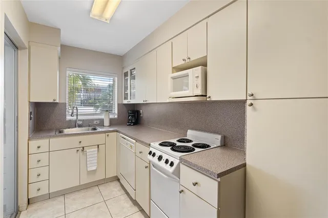 a kitchen with cabinets appliances a sink and a window