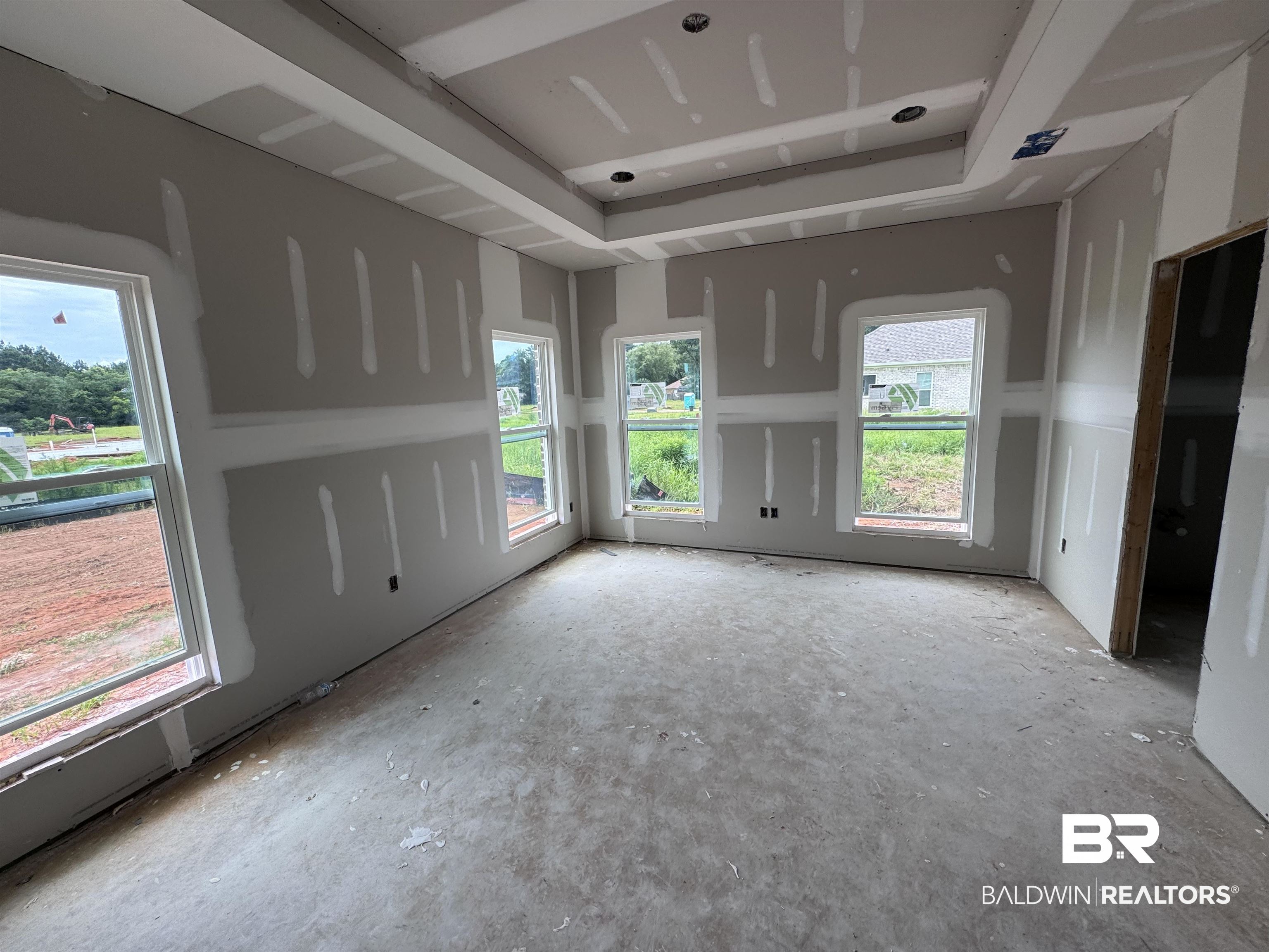 27355 Patch Pl Loop Daphne, AL 36526 - Photo 7 of 17 Room under construction featuring drywall, multiple windows, and a tray ceiling with recessed lighting