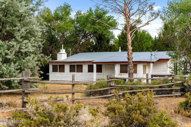 a front view of a house with a yard table and chairs