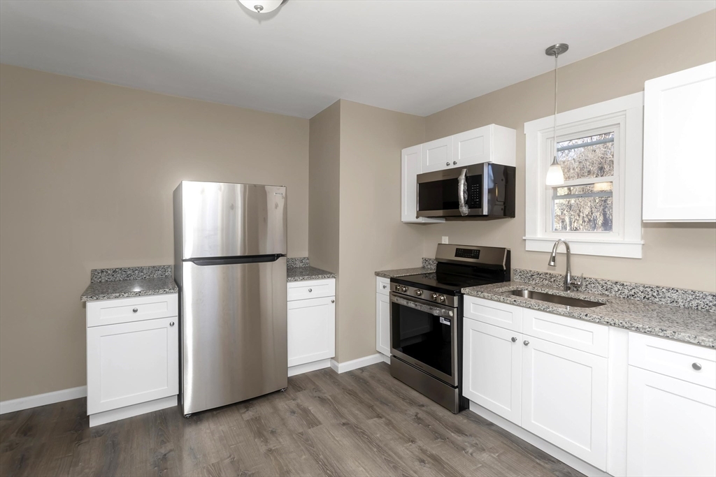 49 View Street Holyoke, MA 01040 - Photo 3 of 34 a kitchen with granite countertop a refrigerator stove and sink