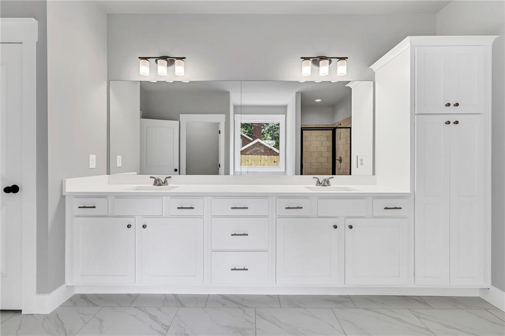 229 East Marable Street Monroe, GA 30655 - Photo 17 of 39 a bathroom with a double vanity sink and mirror