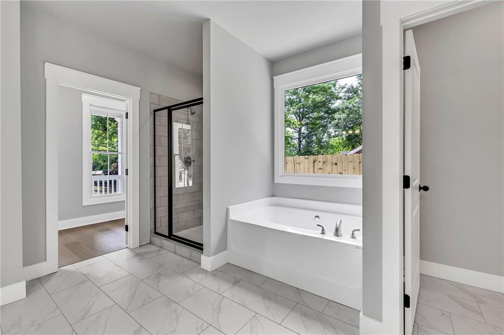 229 East Marable Street Monroe, GA 30655 - Photo 18 of 39 a bathroom with a bathtub and a shower