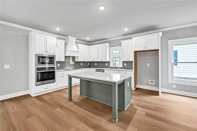 a kitchen with stainless steel appliances granite countertop a stove a sink and a refrigerator