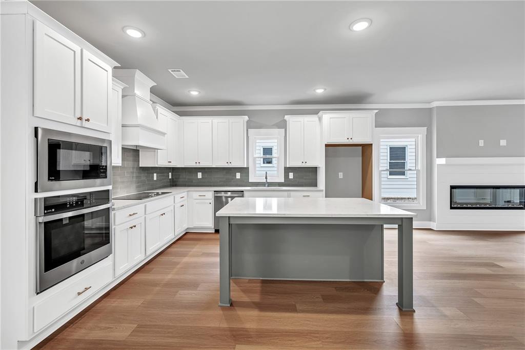 229 East Marable Street Monroe, GA 30655 - Photo 7 of 39 a kitchen with stainless steel appliances granite countertop a stove top oven a sink dishwasher and a refrigerator with wooden floor