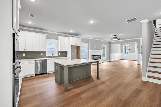 a large kitchen with a center island and stainless steel appliances