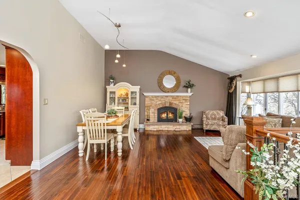 a view of a livingroom with furniture a fireplace wooden floor and furniture