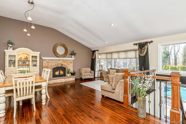 a living room with furniture a fireplace and a large window