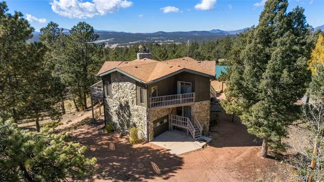 an aerial view of a house with a mountain