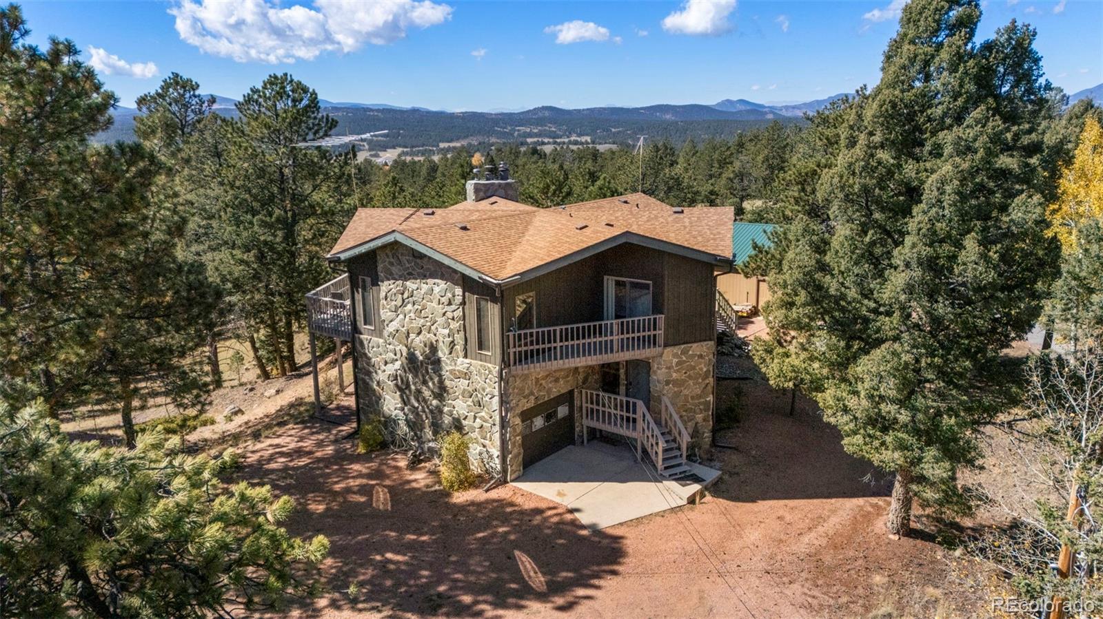 an aerial view of a house with a mountain