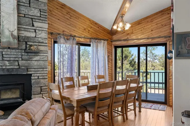 a dining room with furniture a fireplace and large windows