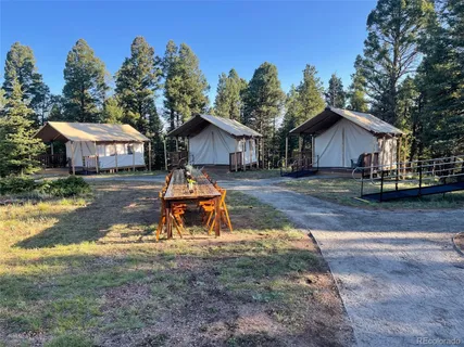 a small house with a big yard and large trees