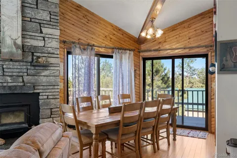 a dining room with furniture a fireplace and large windows
