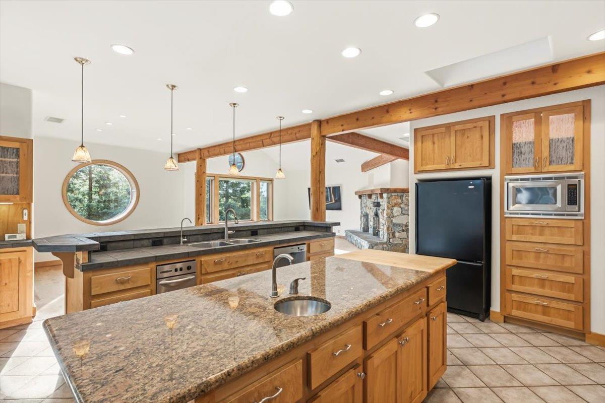12531 Lowhills Road Nevada City, CA 95959 - Photo 22 of 92 a kitchen with stainless steel appliances granite countertop a sink a stove and a wooden cabinets
