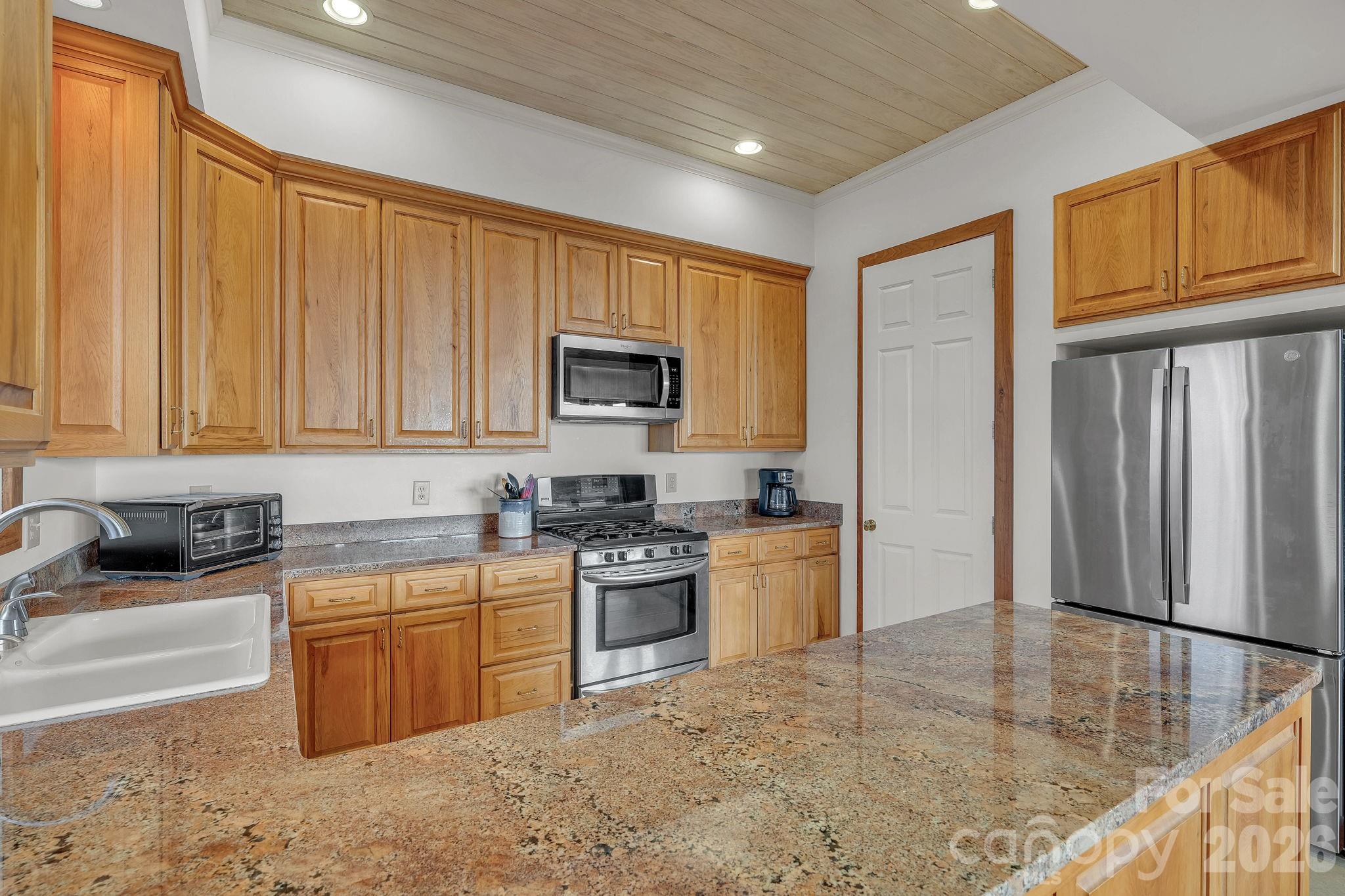 933 Thunder Ridge Lane, Unit 4 & 2 Lenoir, NC 28645 - Photo 14 of 45 a kitchen with stainless steel appliances granite countertop a stove top oven a sink dishwasher and a refrigerator with wooden cabinets