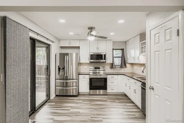 a kitchen with stainless steel appliances granite countertop a refrigerator and a stove top oven
