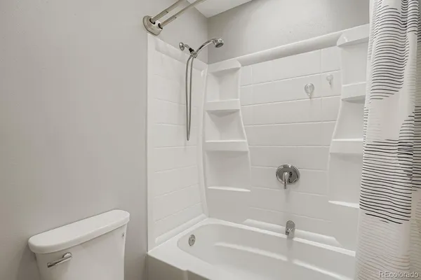 a white bath tub sitting next to a toilet