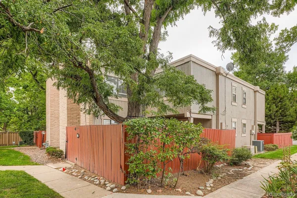 a view of a street with a tree in front of the house