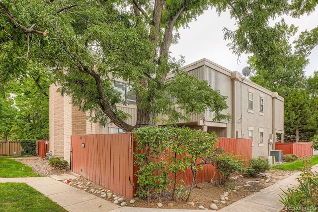 a view of a street with a tree in front of the house