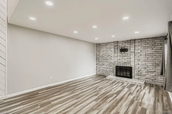 an empty room with wooden floor and fireplace