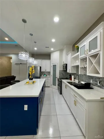 a large kitchen with stainless steel appliances kitchen island granite countertop a sink and cabinets