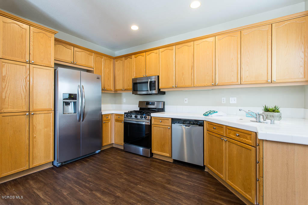 74 Bending Branch Way Simi Valley, CA 93065 - Photo 4 of 41 a kitchen with stainless steel appliances granite countertop a refrigerator stove top oven a sink and dishwasher with wooden floor
