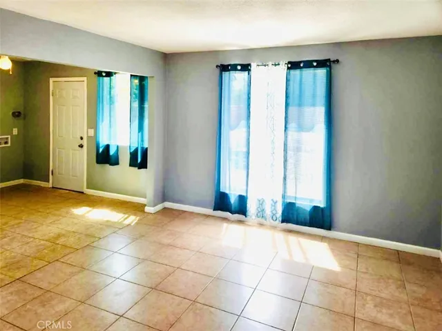 a view of an empty room with window and a bathroom