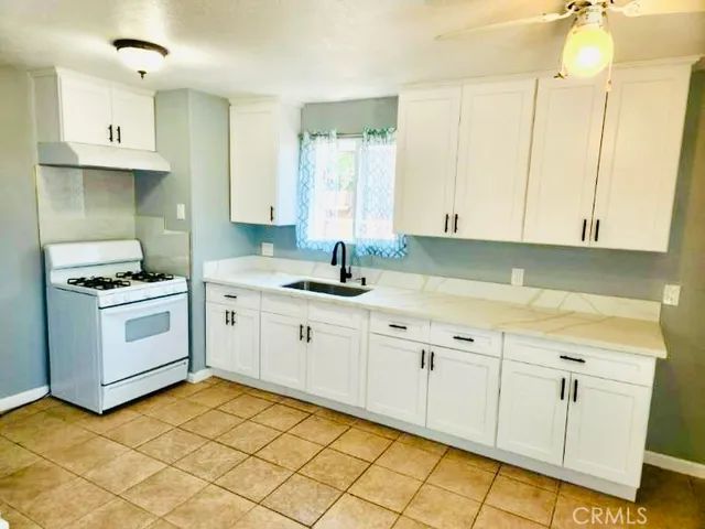 a kitchen with white cabinets and white appliances