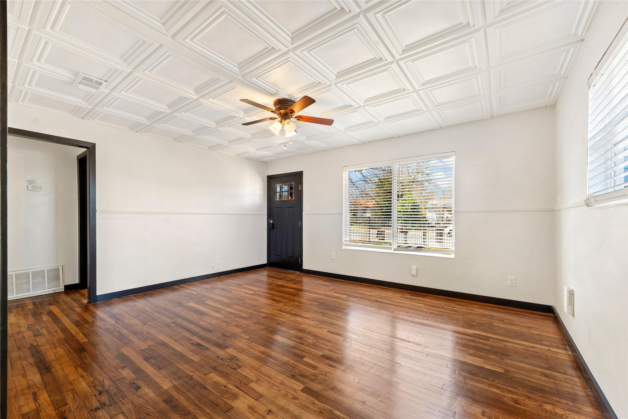 6915 Providence Avenue Austin, TX 78752 - Photo 4 of 27 an empty room with wooden floor and windows