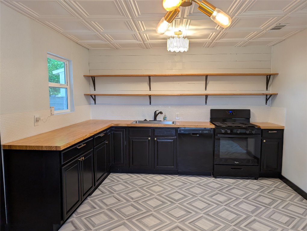 6915 Providence Avenue Austin, TX 78752 - Photo 6 of 27 Kitchen featuring dark cabinets, an ornate ceiling, open shelves, black appliances, and butcher block countertops