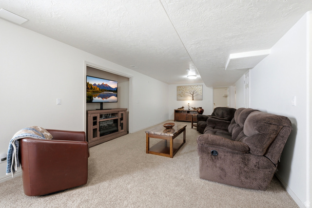 5196 Rodeo Circle Oakley, UT 84055 - Photo 32 of 57 Carpeted living area featuring white walls and a textured ceiling