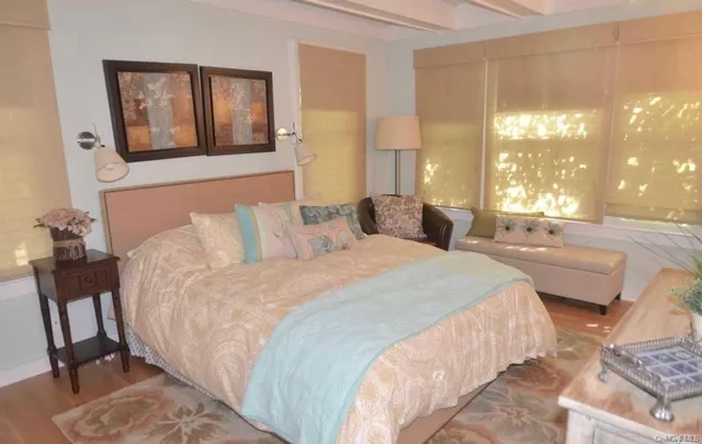 a bedroom with a bed that has a blanket on it and next to a window