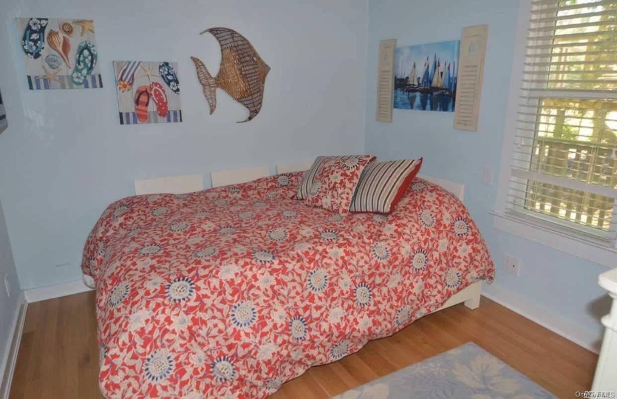207 Wilmot Road Ocean Beach, NY 11770 - Photo 13 of 24 a large bed sitting in a bedroom next to a window