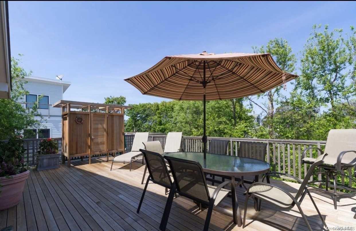 207 Wilmot Road Ocean Beach, NY 11770 - Photo 24 of 24 a view of a chairs and table on the wooden roof deck