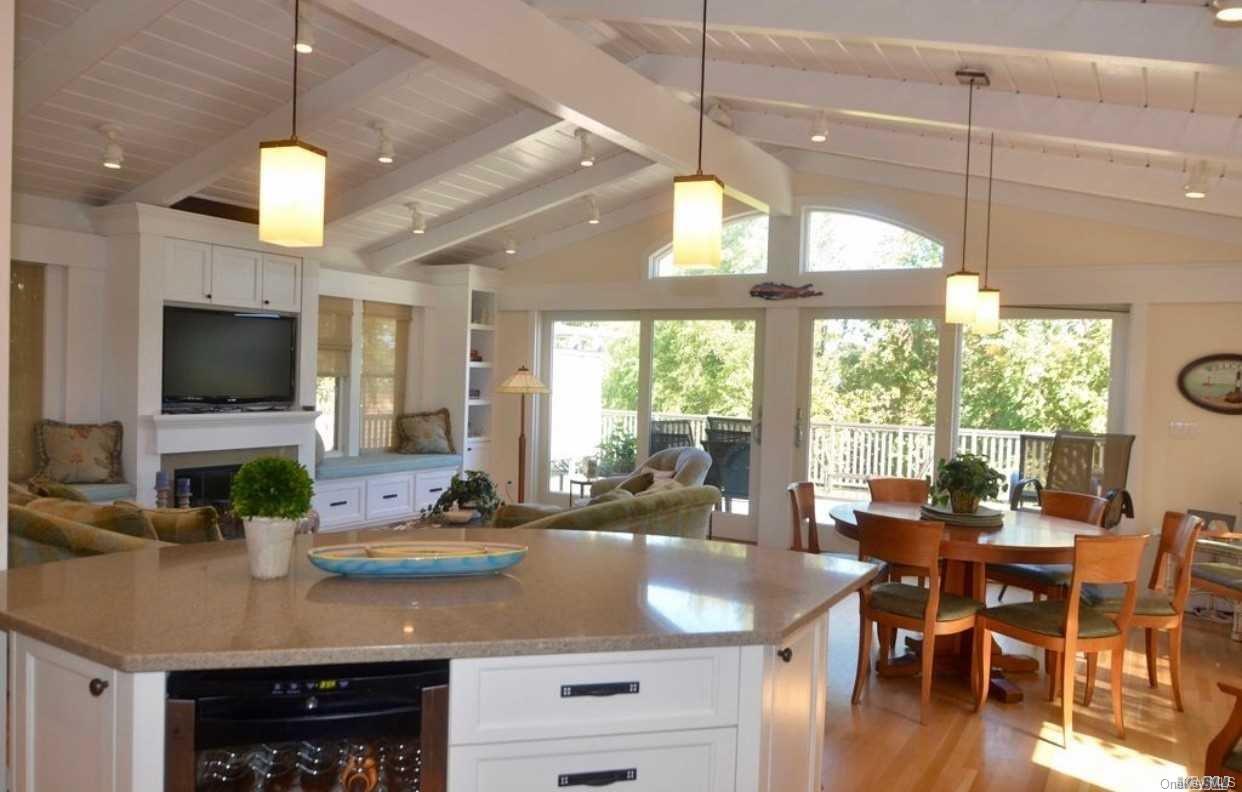 207 Wilmot Road Ocean Beach, NY 11770 - Photo 3 of 24 a view of a dining room and livingroom with furniture wooden floor a chandelier