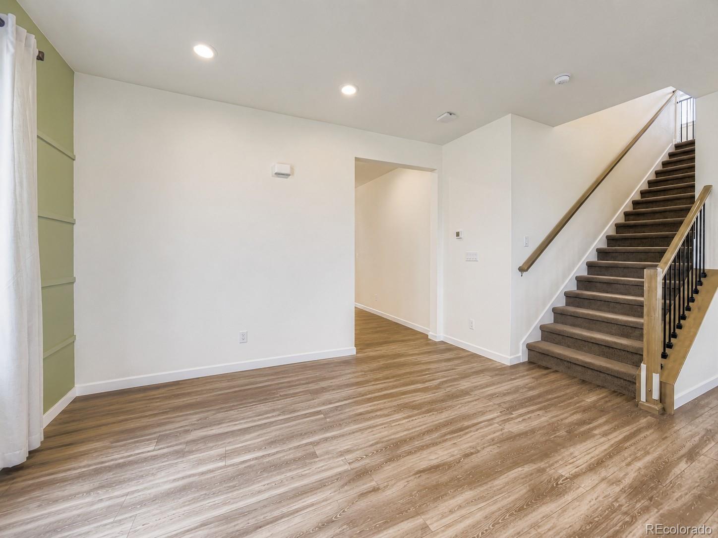 1173 Williams Loop Elizabeth, CO 80107 - Photo 13 of 30 a view of an empty room with wooden floor and stairs