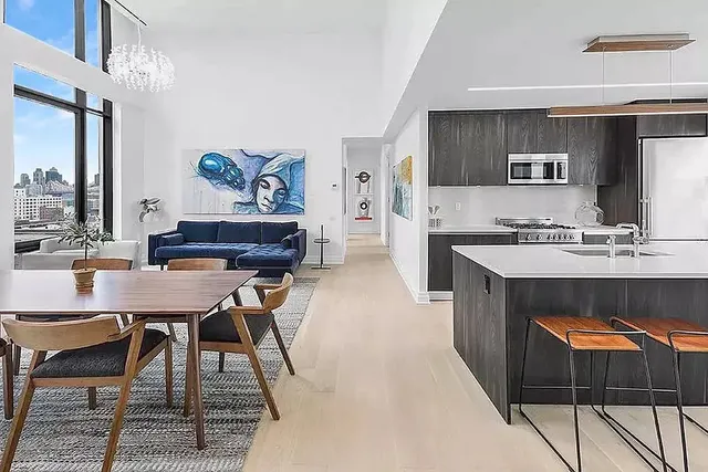 a living room with stainless steel appliances kitchen island granite countertop furniture a rug and a kitchen view