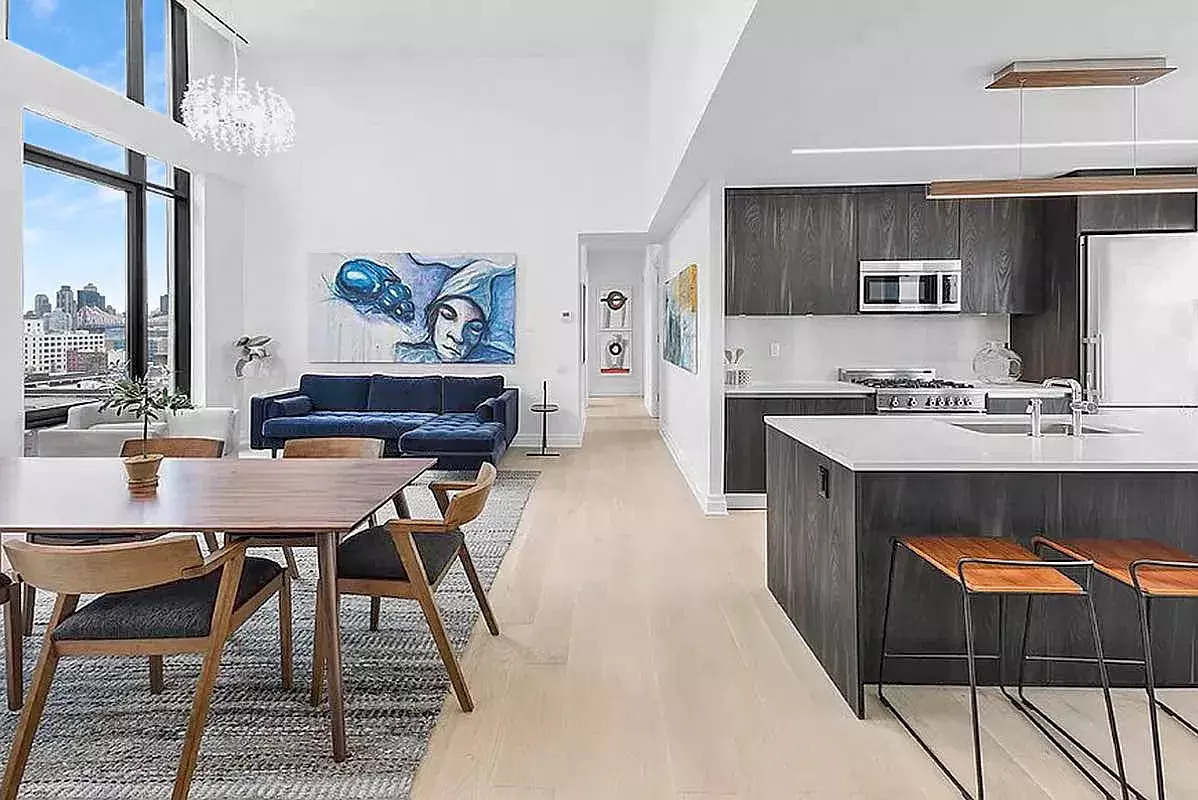 13-33 Jackson Avenue, Unit PHB Queens, NY 11101 - Photo 2 of 2 a living room with stainless steel appliances kitchen island granite countertop furniture a rug and a kitchen view
