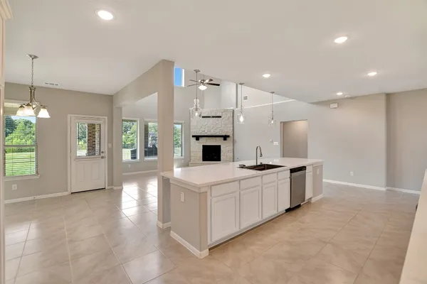 a kitchen with kitchen island granite countertop a sink cabinets and stainless steel appliances