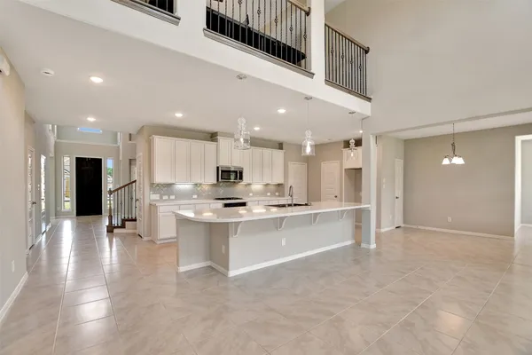 a view of kitchen with kitchen island a sink stainless steel appliances and cabinets