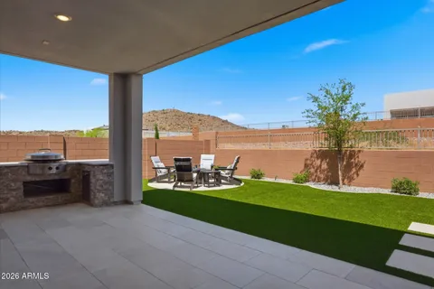 a patio with a table and chairs and a fire pit