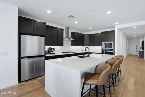 a living room with stainless steel appliances kitchen island granite countertop furniture a dining table and chairs in it