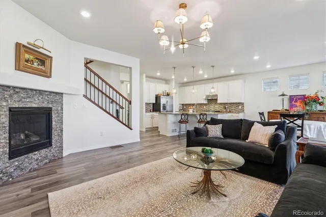a living room with furniture kitchen view and a chandelier