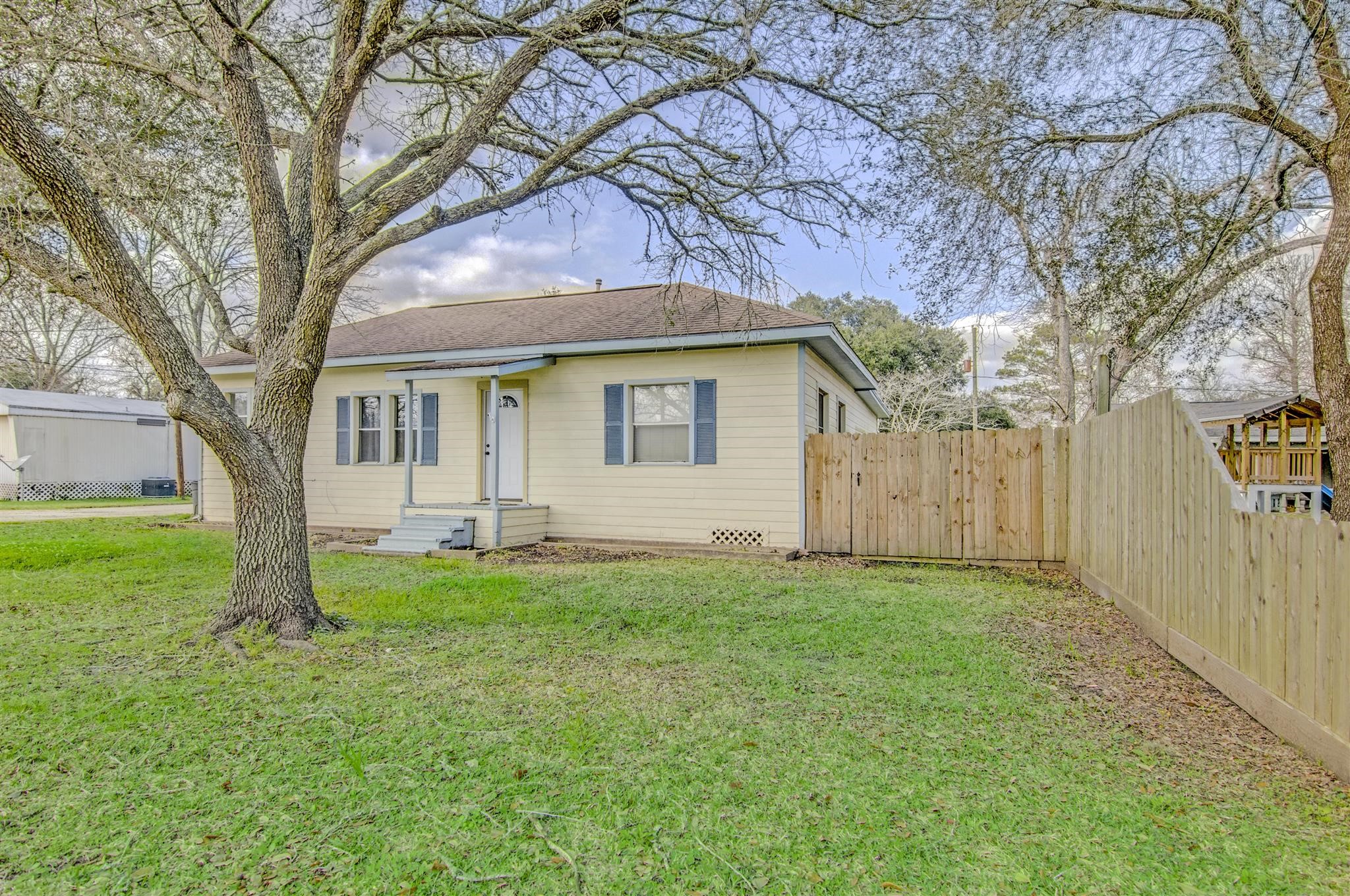 11844 13th Street Santa Fe, TX 77510 - Photo 2 of 17 a backyard of a house with plants and large tree