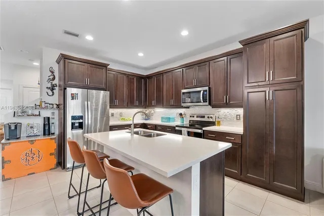a kitchen with stainless steel appliances granite countertop a refrigerator and a stove top oven