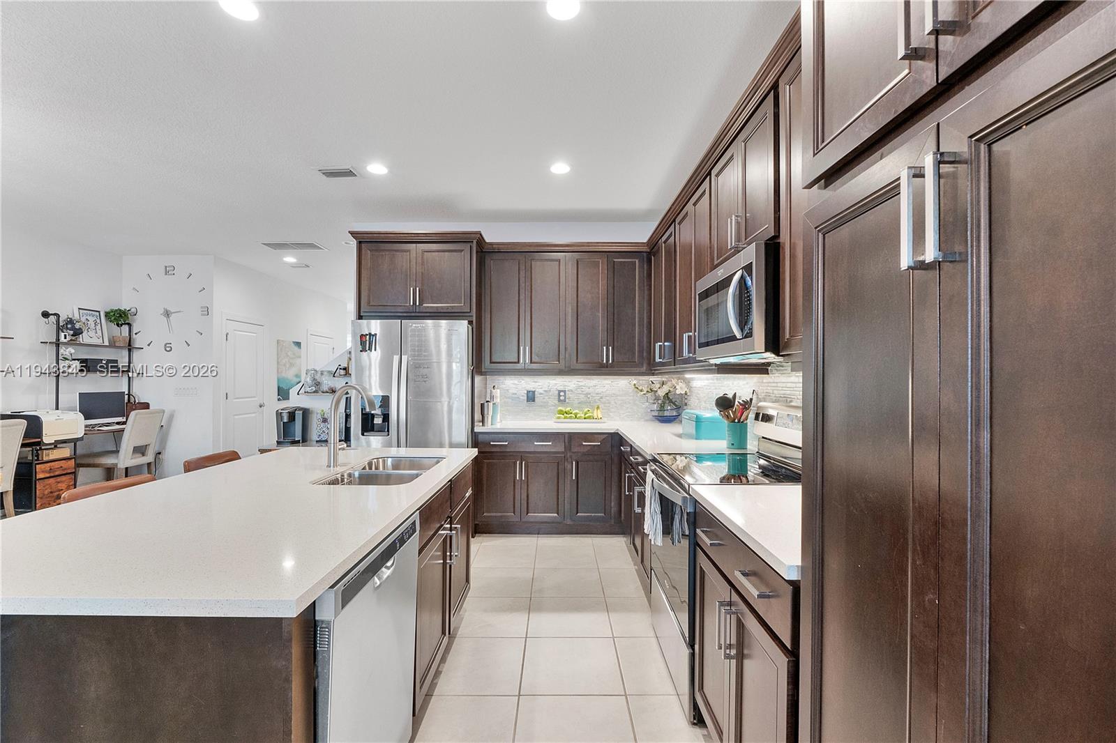 1827 Sandpiper Pointe Place Deerfield Beach, FL 33442 - Photo 16 of 48 a kitchen with stainless steel appliances granite countertop a sink refrigerator and cabinets