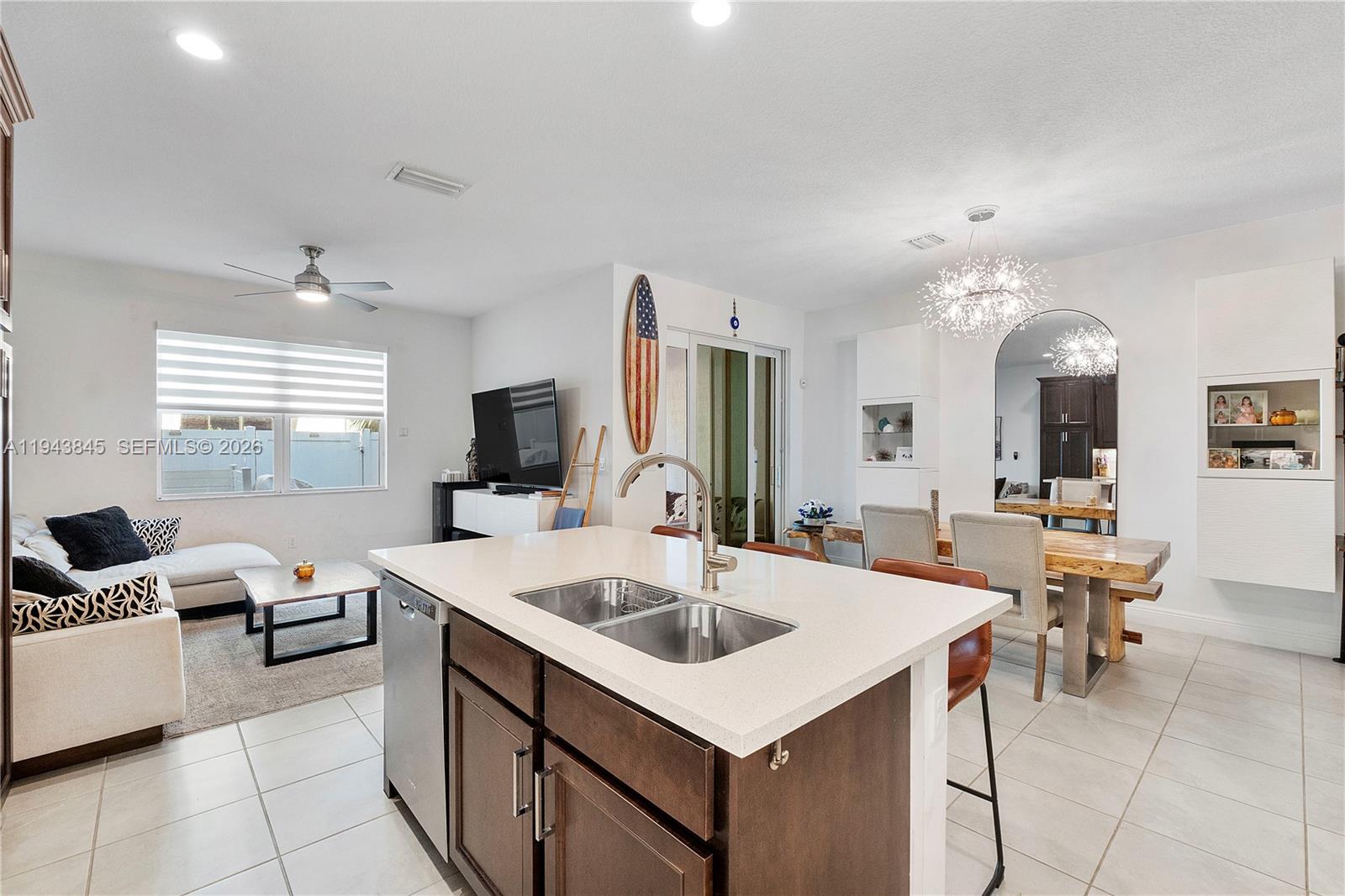 1827 Sandpiper Pointe Place Deerfield Beach, FL 33442 - Photo 17 of 48 a large white kitchen with a stove a sink a dining table and chairs