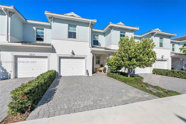 a view of a white house with a street
