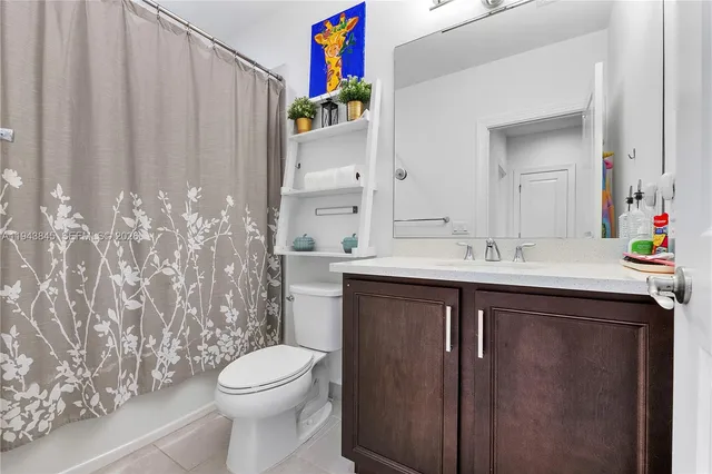 a bathroom with a sink vanity mirror toilet and bathtub
