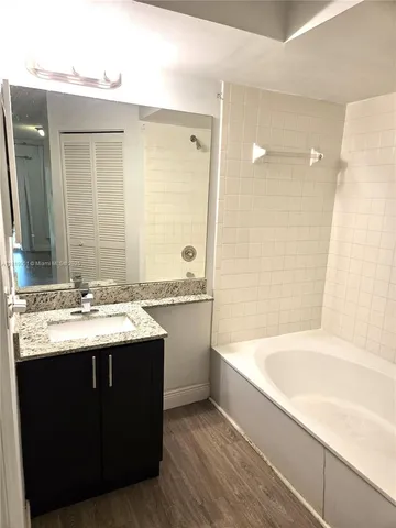 a bathroom with a tub sink shower and mirror